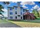 Three-story home's back exterior features a wooden deck with stairs, lots of windows, and brick accents at 1755 Riverpark Dr, Dacula, GA 30019