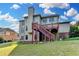 This three-story home's back exterior features a wooden deck with stairs and lots of windows at 1755 Riverpark Dr, Dacula, GA 30019