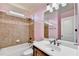 Cozy bathroom with a shower-tub combo featuring decorative tile, a large mirror, and a white sink at 1755 Riverpark Dr, Dacula, GA 30019