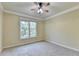 Bedroom features a window with backyard views, neutral carpet, and crown molding at 1755 Riverpark Dr, Dacula, GA 30019