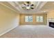 Large main bedroom with coffered ceiling, fireplace, built-in shelves, and neutral carpet at 1755 Riverpark Dr, Dacula, GA 30019