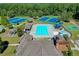 An aerial view of a community pool with tennis courts and other recreational amenities surrounded by mature trees at 1755 Riverpark Dr, Dacula, GA 30019