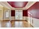 Formal dining room featuring hardwood floors, large windows with white trim, and dark red painted walls at 1755 Riverpark Dr, Dacula, GA 30019