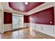 Elegant dining room with hardwood floors, large window, and decorative red ceiling detail at 1755 Riverpark Dr, Dacula, GA 30019