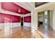 Open-concept dining room with hardwood floors, red accent wall, and wainscoting at 1755 Riverpark Dr, Dacula, GA 30019