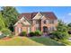 Attractive two-story brick home featuring a lush green lawn and established landscaping at 1755 Riverpark Dr, Dacula, GA 30019