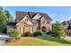Handsome brick home with manicured lawn, landscaping, and charming architectural details at 1755 Riverpark Dr, Dacula, GA 30019