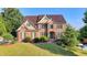 Charming brick two-story home featuring a lush green lawn and established landscaping at 1755 Riverpark Dr, Dacula, GA 30019