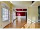 Bright foyer with hardwood floors that lead to a room with a crimson accent wall at 1755 Riverpark Dr, Dacula, GA 30019