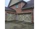 Attached two-car garage with a brick facade and decorative hardware, offering convenient parking and curb appeal at 1755 Riverpark Dr, Dacula, GA 30019