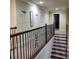 Hallway with carpet and decorative wrought iron railing, leading to staircase and rooms at 1755 Riverpark Dr, Dacula, GA 30019