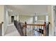 Upstairs hallway with carpet and view of the living room, iron railing, and open space at 1755 Riverpark Dr, Dacula, GA 30019