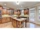 Open kitchen design features a granite island with cooktop, stainless steel appliances, and custom wood cabinetry at 1755 Riverpark Dr, Dacula, GA 30019