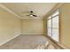 Comfortable living room with neutral carpet, ceiling fan, and natural light from a large window at 1755 Riverpark Dr, Dacula, GA 30019