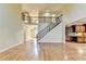 Bright living room with hardwood floors, an open staircase with rod iron, and access to the kitchen at 1755 Riverpark Dr, Dacula, GA 30019