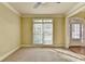 Neutral carpeted living room with ceiling fan, large window, and entrance to dining room at 1755 Riverpark Dr, Dacula, GA 30019