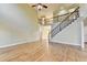 Open living room featuring hardwood floors, a staircase with rod iron railings, and an open floorplan at 1755 Riverpark Dr, Dacula, GA 30019