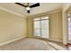 Bright living room features neutral carpet, large window and ceiling fan, and entry door at 1755 Riverpark Dr, Dacula, GA 30019
