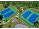 Aerial shot featuring four tennis courts surrounded by green space with a nearby covered picnic area for residents to enjoy at 1755 Riverpark Dr, Dacula, GA 30019