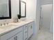 Bathroom with dual sinks, quartz countertop, tile flooring, and framed mirrors at 4320 Sims Park Overlook, Suwanee, GA 30024