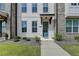 Charming townhome with a blue front door and painted white brick facade with a manicured lawn at 4320 Sims Park Overlook, Suwanee, GA 30024