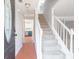 Bright entryway features a staircase and view into the modern kitchen with colorful cabinets at 5265 Forest Downs Cir, Atlanta, GA 30349