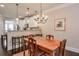 A dining area featuring a wooden table and six chairs, connects to a kitchen with white cabinets and modern appliances at 5315 Hidden Valley Ln, Cumming, GA 30028