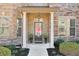 Charming front porch with stone accents, columns, and a decorative front door at 5315 Hidden Valley Ln, Cumming, GA 30028