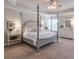 Bright main bedroom showcasing a tray ceiling, a four-poster bed, and a light color palette at 5315 Hidden Valley Ln, Cumming, GA 30028