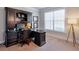 Comfortable office space with a large desk, built-in shelves, and a window at 5315 Hidden Valley Ln, Cumming, GA 30028