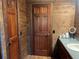 Rustic bathroom features wood paneled walls, vanity, and tiled floors at 6245 Bannister Rd, Cumming, GA 30028