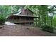 Charming rustic home with a metal roof and inviting porch, complemented by lush greenery and mature trees in the yard at 6245 Bannister Rd, Cumming, GA 30028