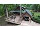 Charming home featuring a wooden deck, carport, and wooded surroundings, creating a serene and private outdoor space at 6245 Bannister Rd, Cumming, GA 30028