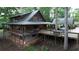 Back exterior view of a rustic home featuring a spacious porch, and a convenient carport, nestled among mature trees at 6245 Bannister Rd, Cumming, GA 30028
