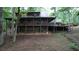 Back exterior view of a rustic home featuring a spacious porch, and a convenient carport, nestled among mature trees at 6245 Bannister Rd, Cumming, GA 30028