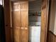 Convenient laundry closet with washer and dryer, enclosed by wood bi-fold doors at 6245 Bannister Rd, Cumming, GA 30028
