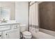 Well-lit bathroom featuring a vanity with white cabinets and modern fixtures and bathtub with tiled walls at 549 Henry Dr, Marietta, GA 30064