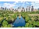 Lake bordered by trees with views of the Atlanta skyline, creating a serene urban retreat at 395 Central Park Ne Pl # 420, Atlanta, GA 30312