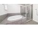 Bathroom featuring a whirlpool tub and a separate tiled shower with glass enclosure at 395 Central Park Ne Pl # 420, Atlanta, GA 30312