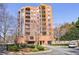 Brick condo building with balconies, lush landscaping, and circular drive entry, offering urban living at 395 Central Park Ne Pl # 420, Atlanta, GA 30312