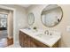 Spacious bathroom with double vanity, round mirrors, wood cabinets, and stylish fixtures at 645 Trailmore Pl, Roswell, GA 30076