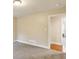 Neutral-toned bedroom featuring a light fixture, gray carpet, white trim, and a door to another room at 645 Trailmore Pl, Roswell, GA 30076