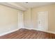 Bedroom with neutral paint, wood floors, and white doors leading to other rooms at 645 Trailmore Pl, Roswell, GA 30076