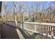 A spacious deck with a white railing and a view of the trees in the background at 645 Trailmore Pl, Roswell, GA 30076