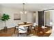 Cozy dining room with hardwood floors, a round table, four chairs, modern light fixture, and a sliding barn door at 645 Trailmore Pl, Roswell, GA 30076