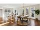 Sunlit dining area featuring hardwood floors, a round wooden table, stylish chairs, and large windows with outdoor views at 645 Trailmore Pl, Roswell, GA 30076