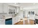 Bright kitchen with white cabinets, stainless steel appliances, quartz countertops, and hardwood floors at 645 Trailmore Pl, Roswell, GA 30076