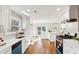 Modern kitchen featuring white cabinets, stainless steel appliances, quartz countertops and hardwood floors at 645 Trailmore Pl, Roswell, GA 30076