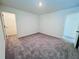 Bright bedroom featuring neutral walls and carpet with access to a walk-in closet and en-suite bathroom at 7722 Sudbury Cir, Covington, GA 30014