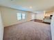 Spacious living room featuring carpeted flooring, natural light, and neutral paint colors at 7722 Sudbury Cir, Covington, GA 30014